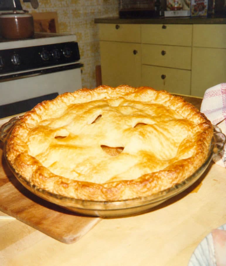 A freshly baked apple pie cooling on a kitchen counter.